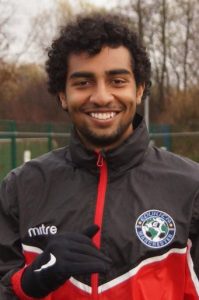 young smiling footballer in rain jacket
