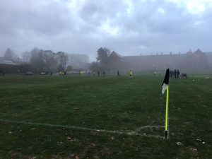 football pitch in the winter mist viewed from the corner flag