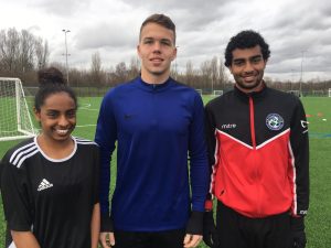 three young footballers smile at camera before they begin the US Soccer Assist scholarship trial day